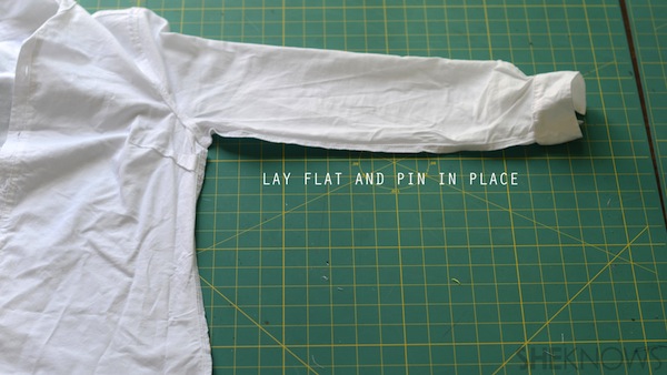 Dress shirt being prepared for tailoring, text reads, "Lay flat and pin in place."